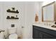 Half bath features floating shelves, sink vanity with bronze faucet, and modern toilet at 763 Arrendale Dr, Marietta, GA 30064