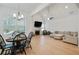 Open concept living area with vaulted ceilings, fireplace, sofa, dining, and hardwood floors at 763 Arrendale Dr, Marietta, GA 30064