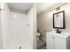 White bathroom featuring a step-in shower with bench and a vanity offering storage space at 932 Mount Airy Sw Dr, Atlanta, GA 30311