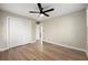 Comfortable bedroom boasts wood-look flooring, a ceiling fan, closet storage, and neutral colors at 932 Mount Airy Sw Dr, Atlanta, GA 30311