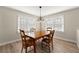 Dining room with wood table, four chairs, a chandelier, and natural light from two windows at 932 Mount Airy Sw Dr, Atlanta, GA 30311