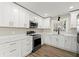 Well-lit kitchen featuring stainless steel appliances, white cabinets, and stylish countertops at 932 Mount Airy Sw Dr, Atlanta, GA 30311