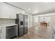 Open kitchen layout with stainless steel appliances, white cabinets, and modern gray flooring at 932 Mount Airy Sw Dr, Atlanta, GA 30311