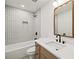 Modern bathroom featuring a tub and shower combo with sleek white tile and a vanity with a quartz countertop at 2327 Doreen Ne Ct, Atlanta, GA 30345