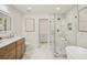 Luxurious bathroom with glass enclosed shower, soaking tub, marble floors, and wood vanity at 2327 Doreen Ne Ct, Atlanta, GA 30345