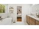 Elegant bathroom with soaking tub, marble accents, wood vanity, and view into main bedroom at 2327 Doreen Ne Ct, Atlanta, GA 30345