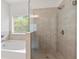 This bathroom features a tub, glass shower, and neutral tiling throughout at 5103 Woodline View Ln, Auburn, GA 30011