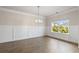 Elegant dining room featuring wainscoting, hardwood floors, and a modern chandelier fixture at 5103 Woodline View Ln, Auburn, GA 30011