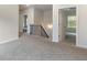 Hallway with stairs and open doorway featuring neutral carpet and natural light at 5103 Woodline View Ln, Auburn, GA 30011