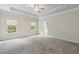 Spacious main bedroom featuring tray ceiling, carpet, and natural light from two windows at 5103 Woodline View Ln, Auburn, GA 30011