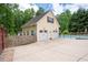 Detached two car garage with an upper level, white doors, and an extra parking pad at 96 Grover Way, Dallas, GA 30157