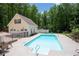 A spacious backyard with an in-ground pool and detached garage surrounded by lush greenery at 96 Grover Way, Dallas, GA 30157