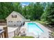 A backyard with a long rectangular in-ground pool and detached garage boasts a spacious area at 96 Grover Way, Dallas, GA 30157