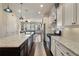 Open-concept kitchen with white cabinets, stainless steel appliances, and a view into the living area at 1671 Hammock Dr, Smyrna, GA 30080