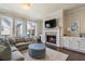 Comfortable living room with a fireplace, large sofa, and plenty of natural light at 1671 Hammock Dr, Smyrna, GA 30080