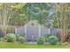 Lush backyard features a decorative fence, mature trees, green grass, and manicured bushes at 15 Northwood Ne Ave, Atlanta, GA 30309