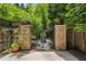 Landscaped backyard features brick columns, wrought iron gate, and potted plants for a private outdoor space at 1601 Marlbrook Ne Dr, Atlanta, GA 30307
