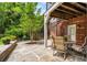 Charming backyard patio area featuring stone flooring, a dining table, and a spiral staircase to the upper level at 1601 Marlbrook Ne Dr, Atlanta, GA 30307