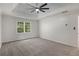 Large bedroom with a tray ceiling, ceiling fan, and a window; featuring access to another room at 535 Emerald Pkwy, Sugar Hill, GA 30518