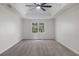 Spacious bedroom featuring a tray ceiling, ceiling fan, and a large window for natural light at 535 Emerald Pkwy, Sugar Hill, GA 30518
