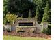Stone sign for Emerald Lake with landscaped flower beds, shrubbery, and mature trees in the background at 535 Emerald Pkwy, Sugar Hill, GA 30518