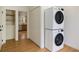 Convenient laundry room with stacked washer and dryer, and storage shelves at 535 Emerald Pkwy, Sugar Hill, GA 30518