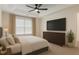 Comfortable bedroom with tray ceiling, large window, dresser, and a wall-mounted TV at 535 Emerald Pkwy, Sugar Hill, GA 30518