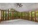 Screened-in porch with slate tile flooring and a ceiling fan overlooking trees at 535 Emerald Pkwy, Sugar Hill, GA 30518