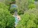 Aerial view showcasing a tennis court, swimming pool with gazebo, and lush landscaping at 1206 Canyon Point Cir, Roswell, GA 30076