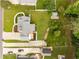 Aerial view shows a spacious home, lush lawn, and a tranquil, wooded perimeter at 1320 Pinyon Pl, Lawrenceville, GA 30043