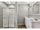 Bathroom featuring a double sink with white cabinets and quartz countertop, a shower with sliding door and modern lighting at 1320 Pinyon Pl, Lawrenceville, GA 30043