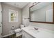 Bathroom featuring a white vanity with a quartz countertop, wood framed mirror and wood look tile floor at 1320 Pinyon Pl, Lawrenceville, GA 30043