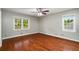 Bedroom features hardwood floors, neutral walls, baseboard trim, and two windows providing ample natural light at 1320 Pinyon Pl, Lawrenceville, GA 30043
