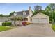 Classic exterior showcasing a two-car garage, well-kept lawn, and inviting curb appeal at 1320 Pinyon Pl, Lawrenceville, GA 30043