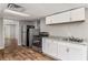 Kitchen area with white cabinets, stainless steel appliances, and wood look flooring at 1320 Pinyon Pl, Lawrenceville, GA 30043