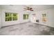 Bright living room with modern gray tile floors, ceiling fan, and large windows with a view of the greenery outside at 1320 Pinyon Pl, Lawrenceville, GA 30043