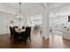 Open concept dining area with hardwood floors, modern chandelier, and a view of the living room and kitchen at 1074 Heyward Way, Alpharetta, GA 30009