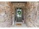 Inviting front entry with a stone surround, decorative wreath, and a charming 'hello' doormat at 1074 Heyward Way, Alpharetta, GA 30009