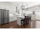 Modern kitchen featuring stainless steel appliances, white cabinets, herringbone backsplash, and wooden barstools at 1074 Heyward Way, Alpharetta, GA 30009