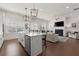 Spacious kitchen island with a sink and stainless steel dishwasher, open to a living room with a fireplace at 1074 Heyward Way, Alpharetta, GA 30009