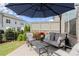 Cozy patio with modern outdoor furniture, a shade umbrella, and lush flower landscaping at 1074 Heyward Way, Alpharetta, GA 30009
