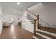 Wooden staircase with white risers, hardwood floors and a decorative chair at 1074 Heyward Way, Alpharetta, GA 30009