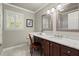 Bathroom with a vanity with a marble countertop, matching mirrors, and natural light at 1328 Wyntercreek Rd, Atlanta, GA 30338