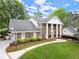 Two-story brick home with columns, attached garage, and lush landscaping at 1328 Wyntercreek Rd, Atlanta, GA 30338
