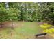 Green space with manicured lawn, scattered benches, mature trees, and surrounding foliage in a community green area at 1328 Wyntercreek Rd, Atlanta, GA 30338