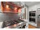 Close-up of the kitchen featuring a professional grade cooktop and stainless steel appliances at 1328 Wyntercreek Rd, Atlanta, GA 30338