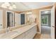 Bright bathroom featuring double vanity sinks, tile floors, and an open doorway to the bedroom at 1658 Mount Paran Nw Rd, Atlanta, GA 30327