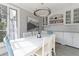 Light-filled dining area with white table, stylish lighting, and built-in cabinets at 1658 Mount Paran Nw Rd, Atlanta, GA 30327