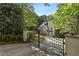 Long driveway leading to an elegant home, visible through a black iron gate with manicured hedges at 1658 Mount Paran Nw Rd, Atlanta, GA 30327