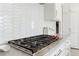 Close-up of a modern gas cooktop, subway tile backsplash, and marble countertops in a bright kitchen at 1658 Mount Paran Nw Rd, Atlanta, GA 30327